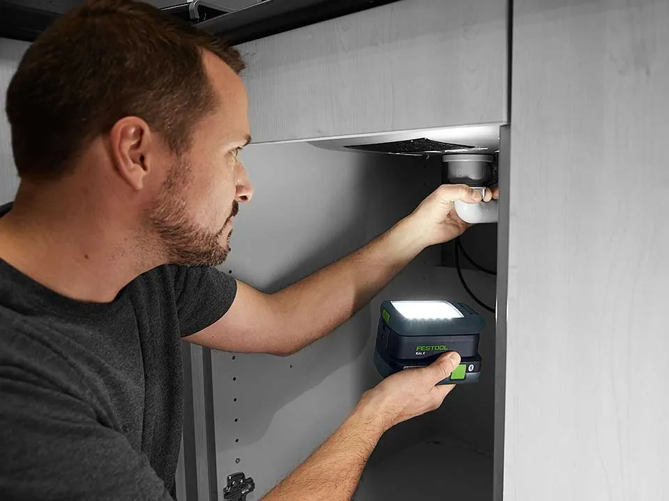 Mężczyzna podświetla podłączenie umywalki za pomocą SYSLITE KAL 2