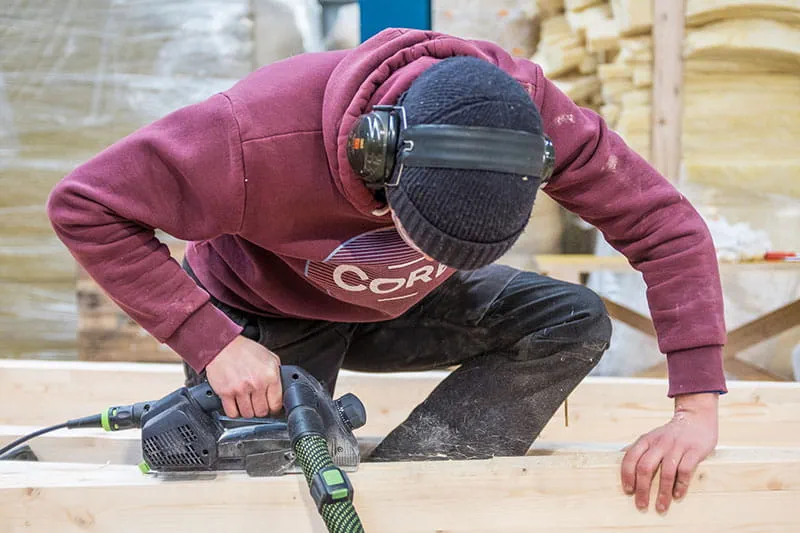 Drewniane belki są poddawane obróbce za pomocą struga jednoręcznego firmy Festool